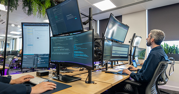 Developers sat working with multiple screens