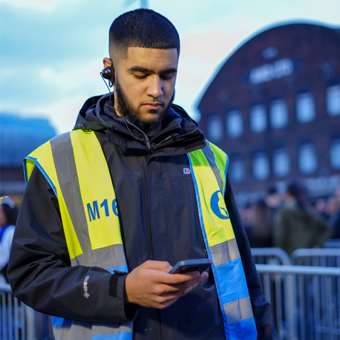 A security guard on-site checking his mobile app