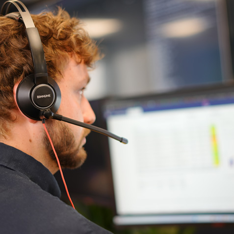 An operative with a headset monitoring an issue