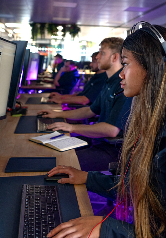 A female operative with a headset working at her computer